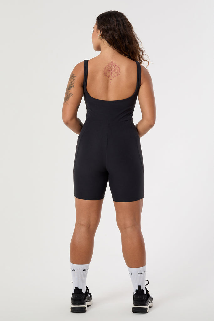 Black onesie with a cute square neckline, low back, high waist seam, and double side pockets. Perfect for every activity, back view
