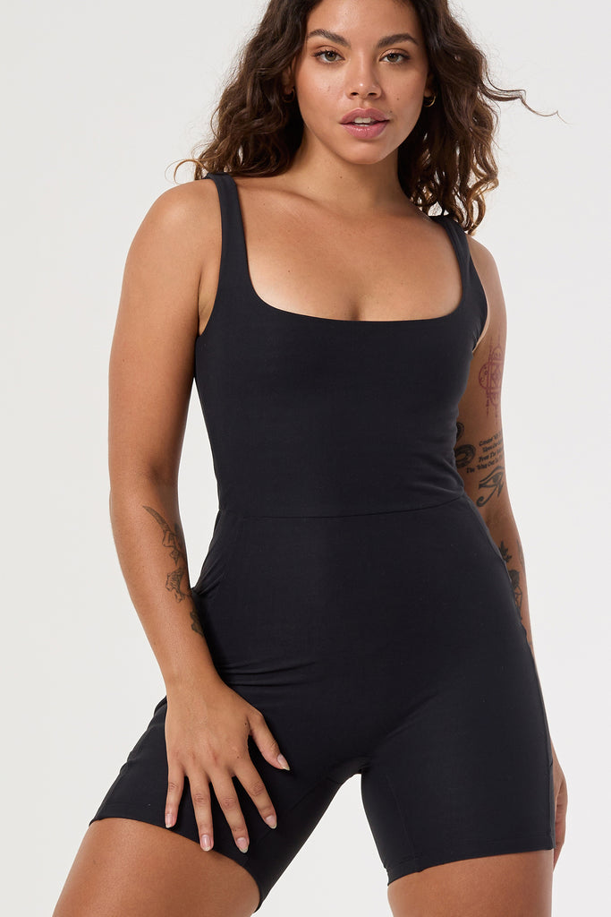 Black onesie with a cute square neckline, low back, high waist seam, and double side pockets. Perfect for every activity, close up