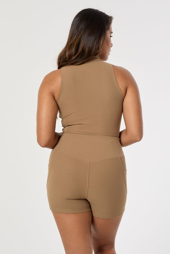 The perfect triple-layered light brown sports bra with removable cups and a front zip. Perfect for low-impact workouts, worn zipped or unzipped in and out of the gym, back view