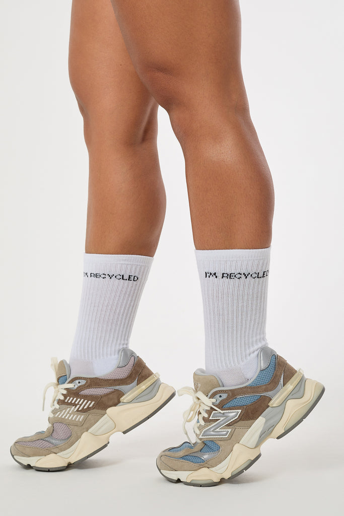 White sweat-wicking, cushioned socks with ribbed arch support, seamless toe, and reinforced heel. 97% recycled polyester.