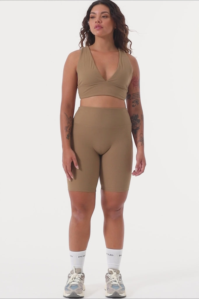 Light brown deep V-neck low-impact support with a seamless fit, removable padding for all-day comfort and style.