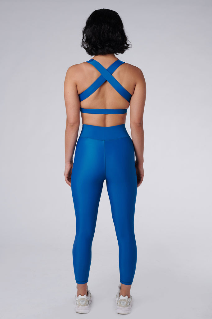 High-waisted blue leggings with a compressive waistband for a slimming, luxurious fit. Perfect for high-intensity activities, back view