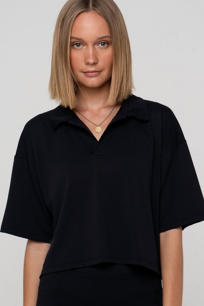 Black Boxy Polo Shirt with lightweight, airy sleeves for free movement, front view close up