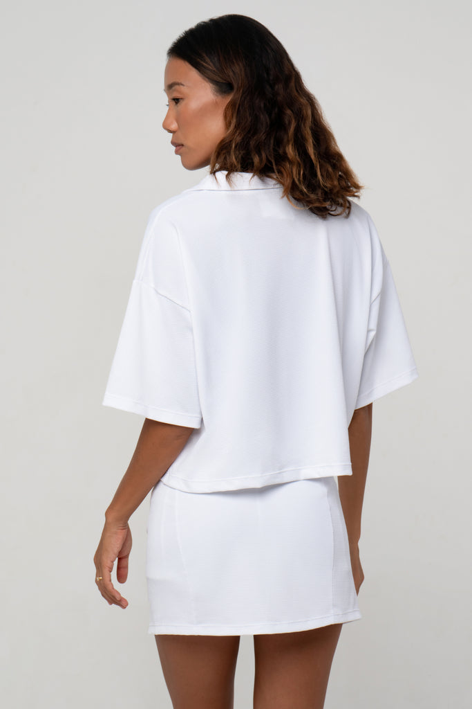 White Boxy Polo Shirt with lightweight, airy sleeves for free movement , back view
