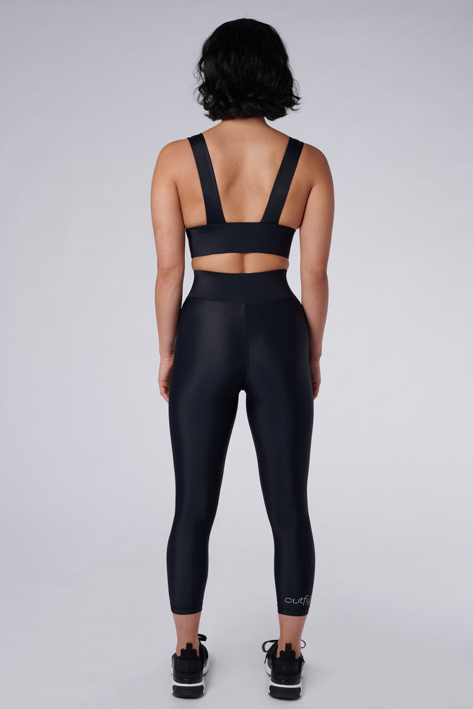 High-waisted black leggings with a compressive waistband for a slimming, luxurious fit. Perfect for high-intensity activities, back view