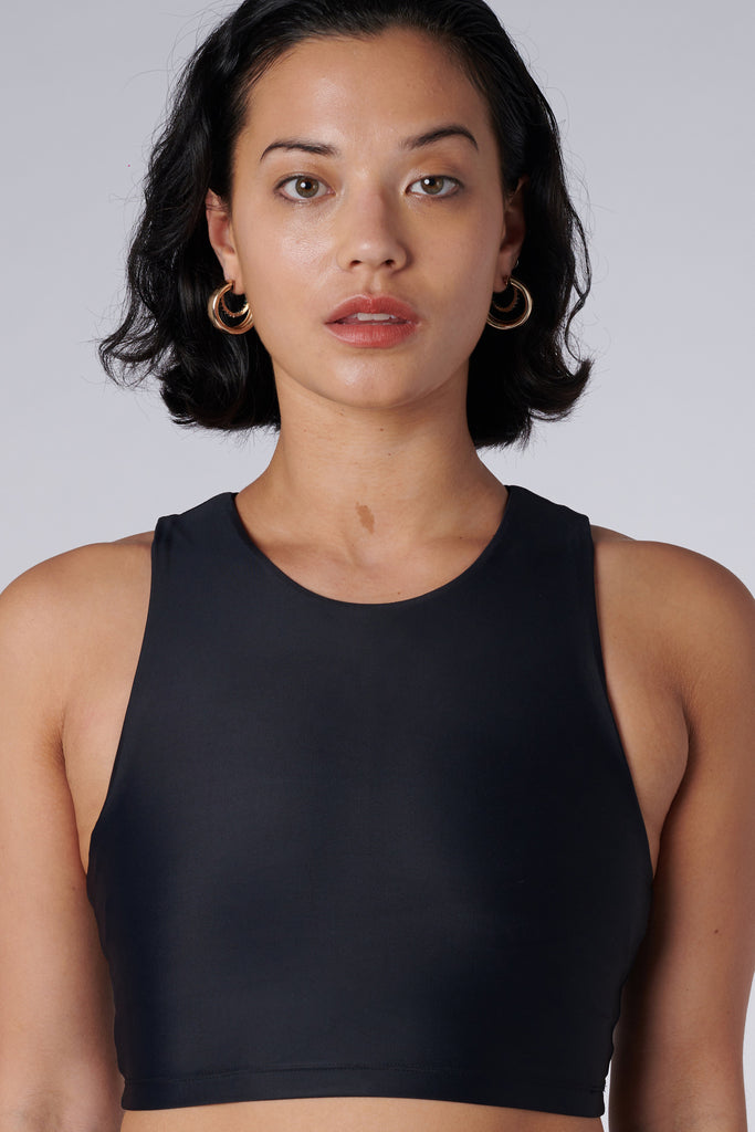 Award-winning black crop top with a flattering cut, high neckline for coverage, and in-built sports bra. Medium impact support, perfect for day wear, close up