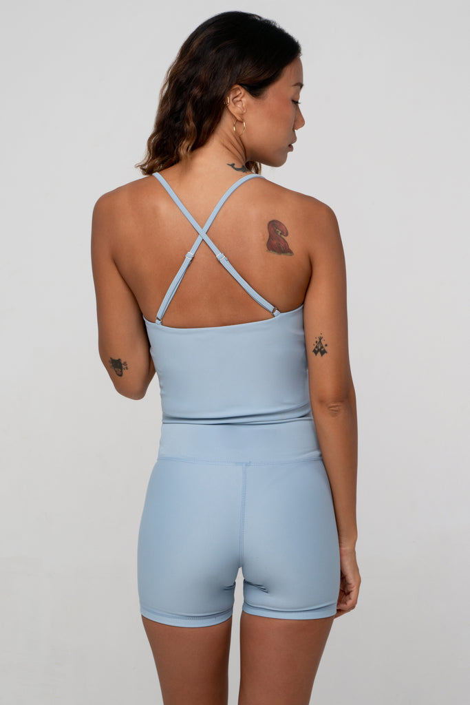 Light blue seamless crop top with cross back adjustable straps, in-built sports bra, and removable padding, back view