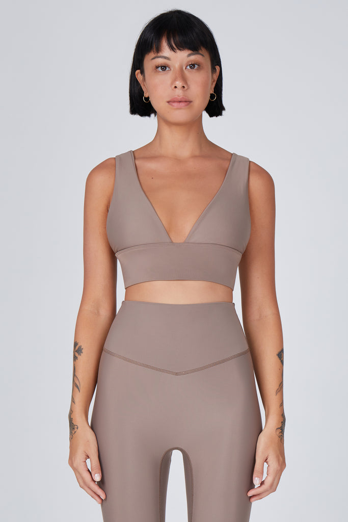 Classy and sexy sports bra in beige with low-impact support, seamless fit, removable padding, and a wide under-bust elastic band front view