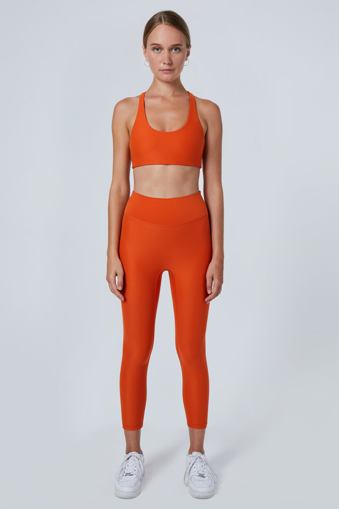 Super soft orange high-waisted 7/8 leggings without a front seam for all-day comfort. Perfect for non abrasive sports and everyday wear, front view