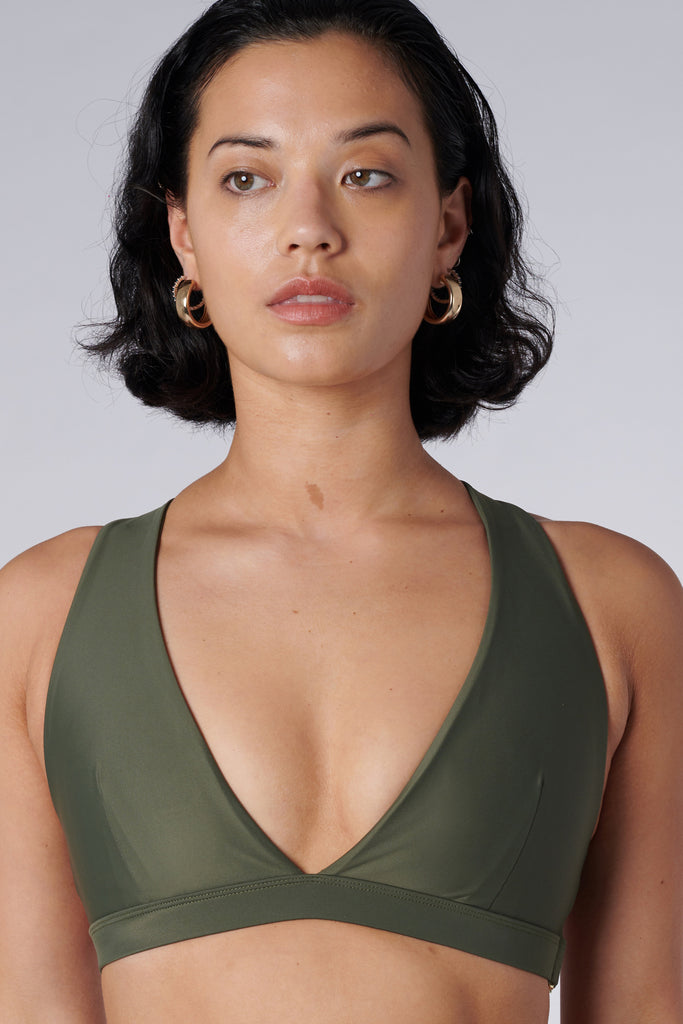 Olive green, medium to high impact support with removable padding, strong elastic cross back straps, and adjustable gold-hook closure, close up