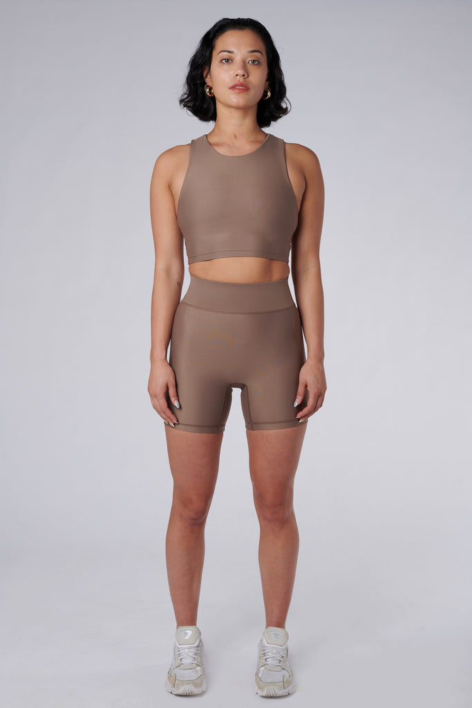 High-waisted beige bicycle shorts with a secure, compressive fit. No front seam and flattering wide waist band, front view