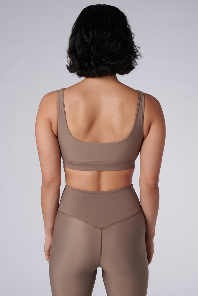 Beige classic sports bra with mid to high impact support, seamless fit that holds everything in place, removable padding, back view