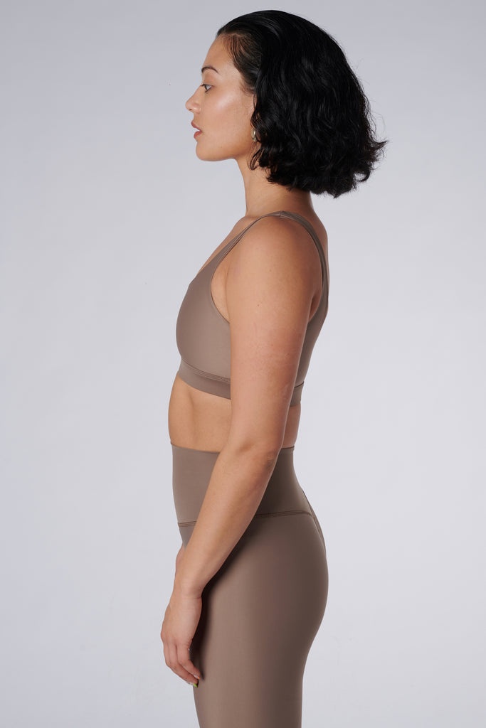 Beige classic sports bra with mid to high impact support, seamless fit that holds everything in place, removable padding, side view