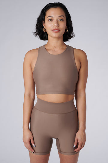 Award-winning sand coloured crop top with a flattering cut, high neckline for coverage, and in-built sports bra. Medium impact support, perfect for day wear