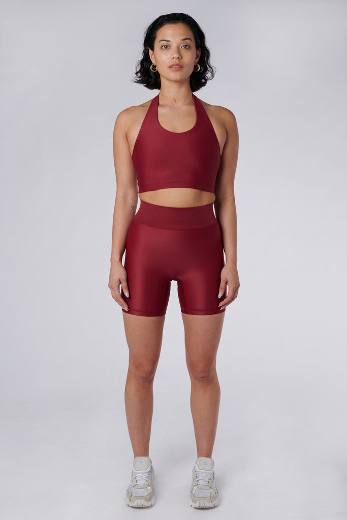 High-waisted dark red bicycle shorts with a secure, compressive fit. No front seam and flattering wide waist band, front view