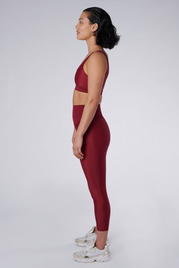 Versatile dark red 7/8 compressive leggings that fit like a glove and stay put during workouts. Squat proof and no front seam for ultimate comfort, side view